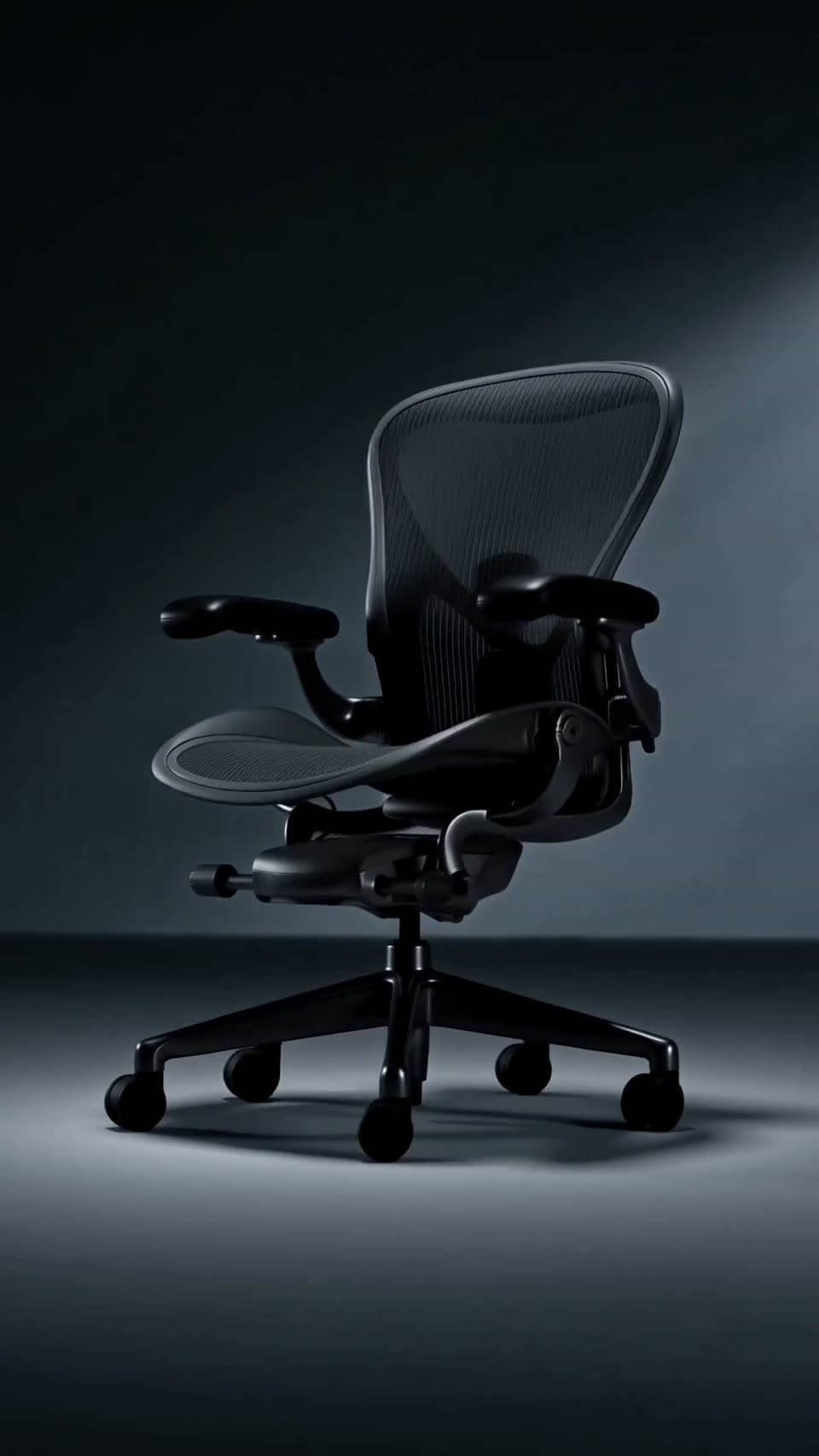Black ergonomic office chair in a dark studio